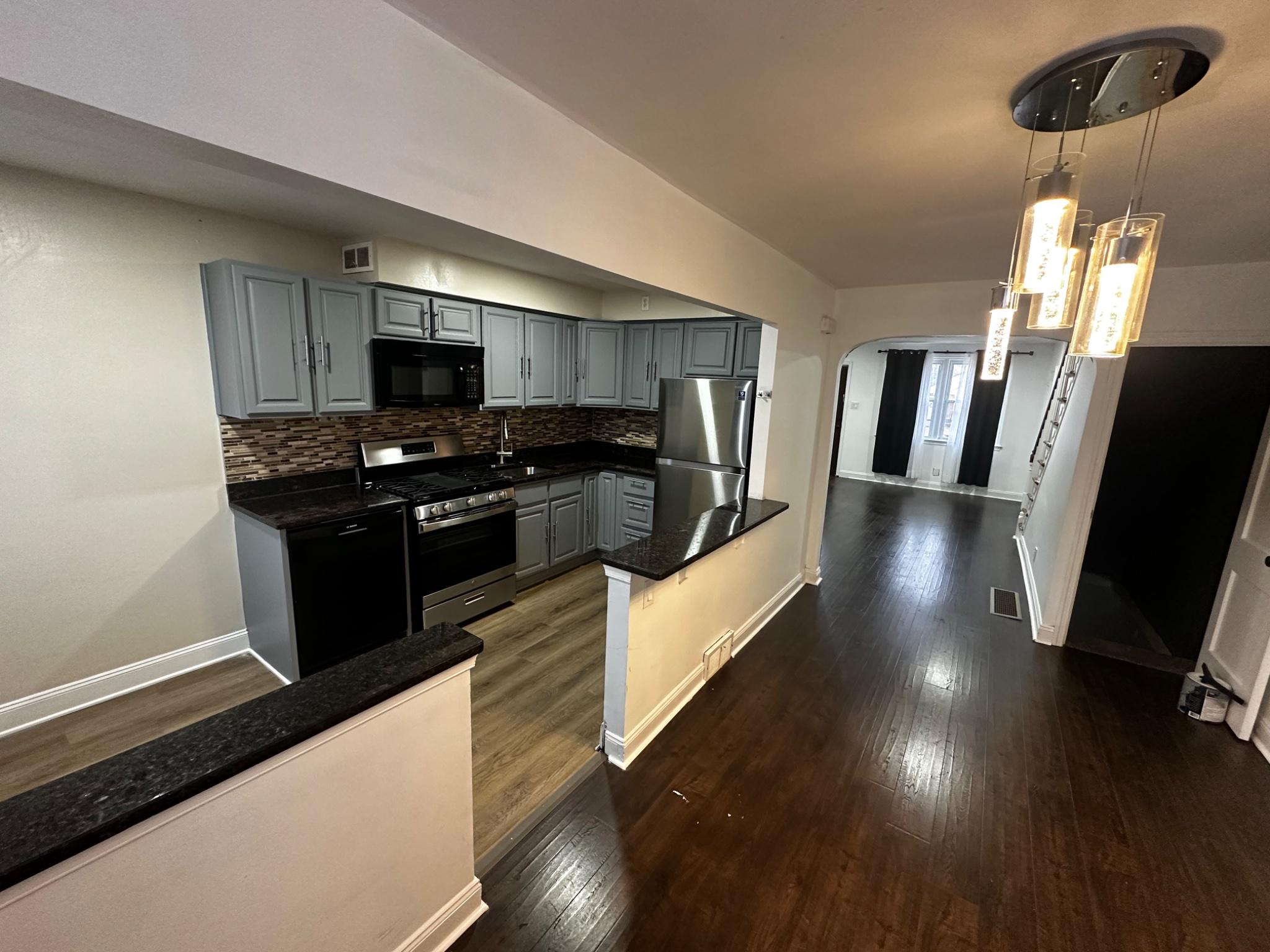 3050 Willits Road Philadelphia, PA 19136 - Photo 5 of 22 a kitchen with stainless steel appliances a stove a sink a microwave a refrigerator a stove a microwave with wooden floors and cabinets