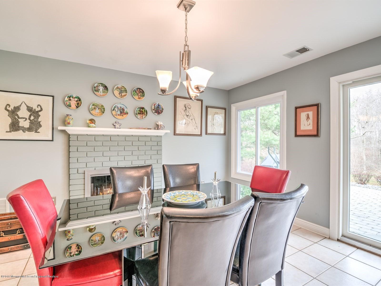 24 Valley Road Manalapan, NJ 07726 - Photo 13 of 30 a dining room with furniture a fireplace and a chandelier