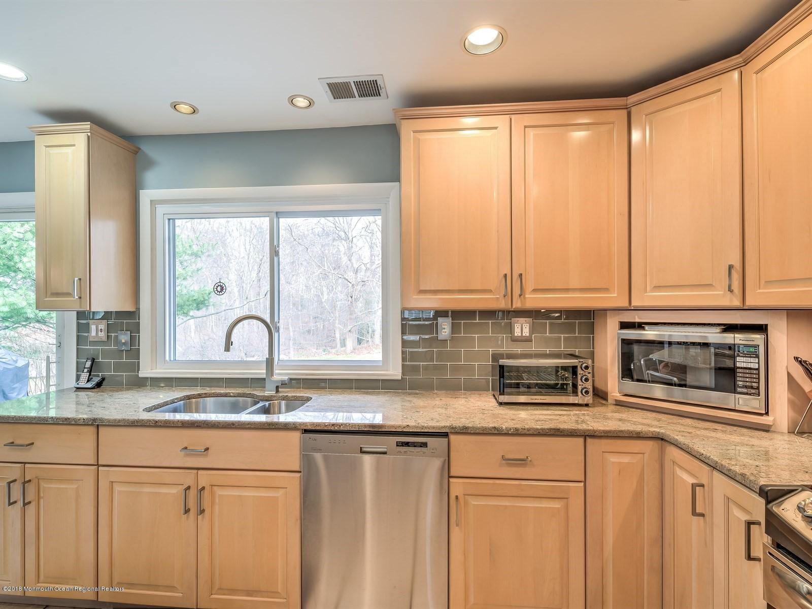 24 Valley Road Manalapan, NJ 07726 - Photo 17 of 30 a kitchen with stainless steel appliances white cabinets a sink and a large window