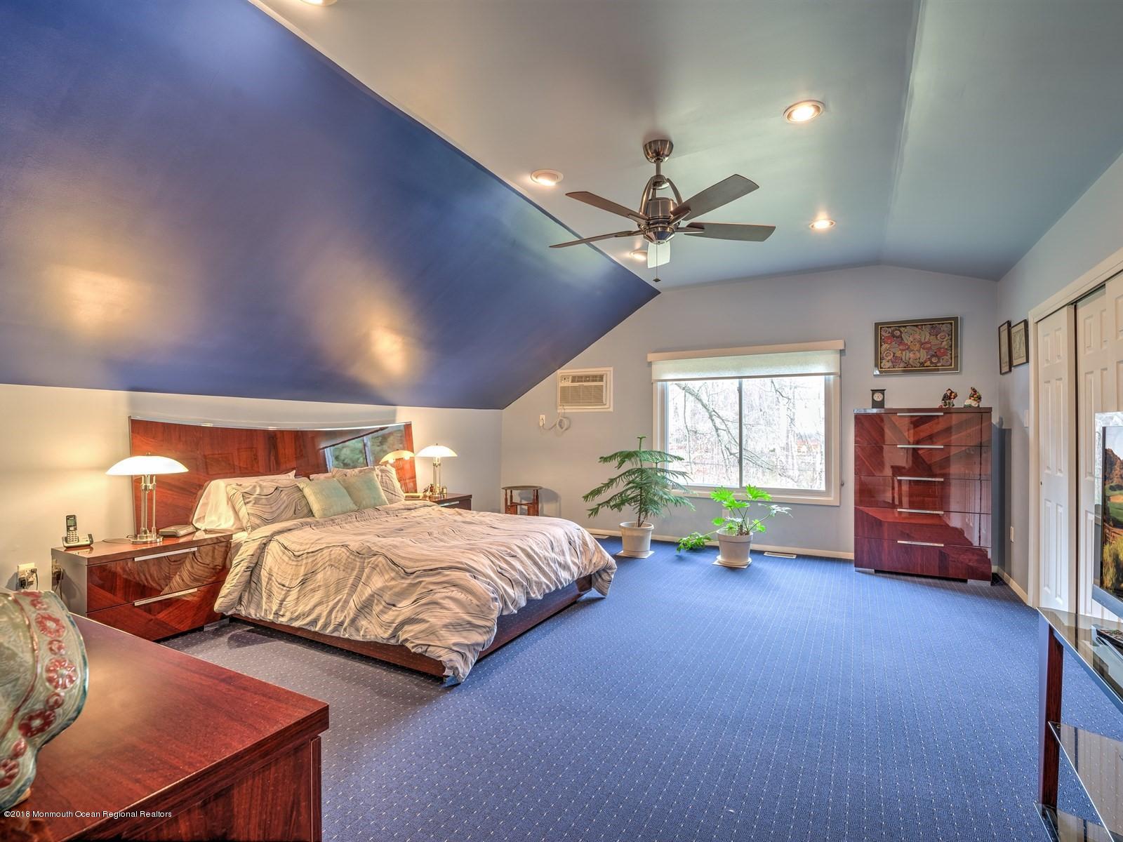 24 Valley Road Manalapan, NJ 07726 - Photo 21 of 30 a bedroom with a bed a chandelier and a large window