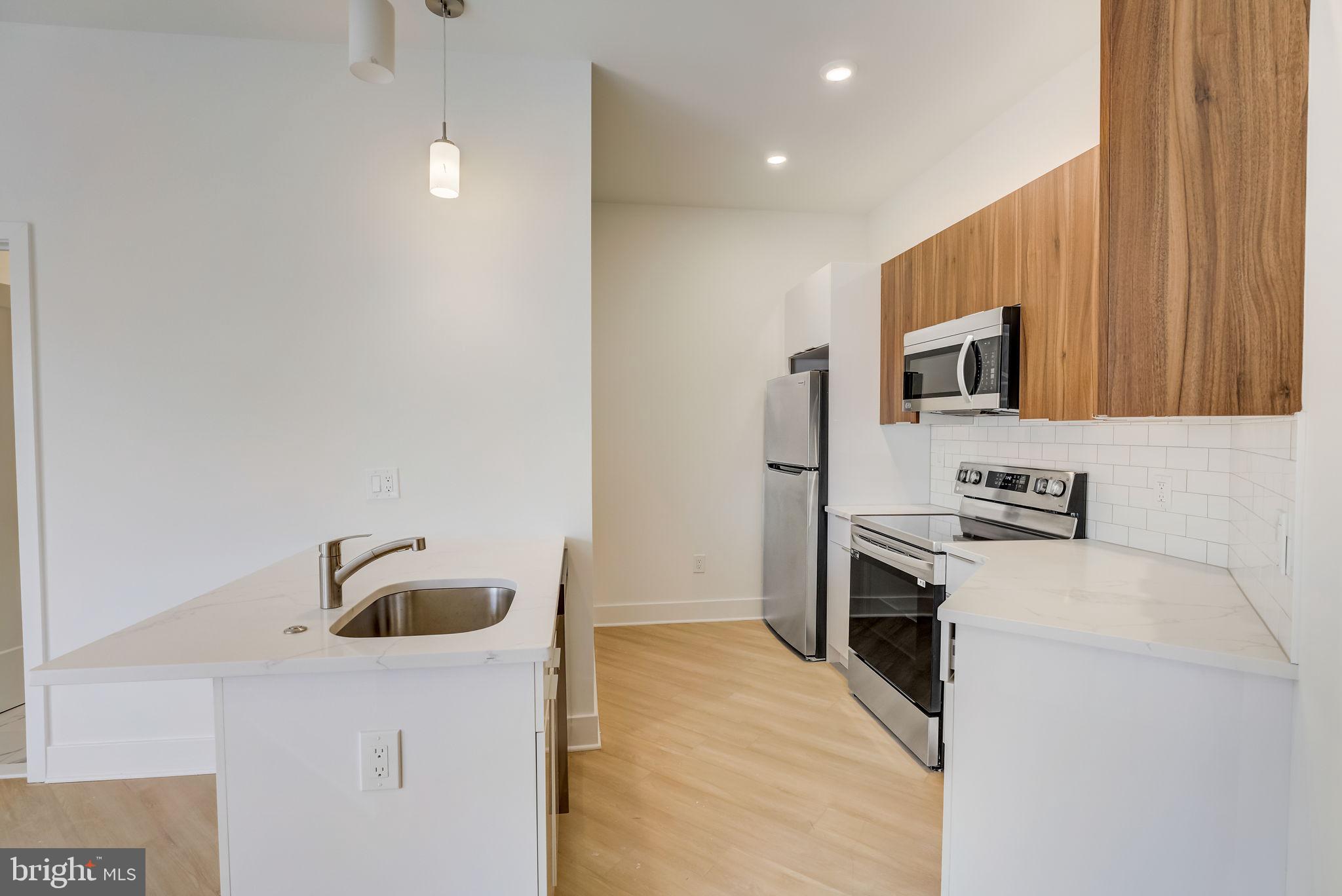 a kitchen with stainless steel appliances granite countertop a sink and a stove