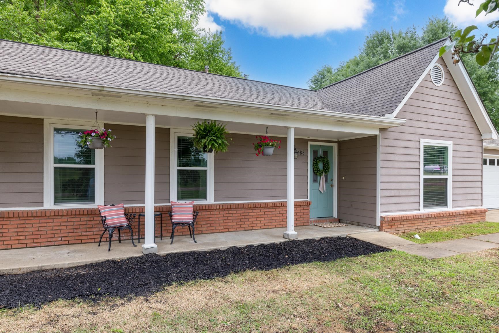 586 Beaver Road Munford, TN 38058 - Photo 2 of 21 Exterior featuring a covered front porch with white columns, light brown siding, and a red brick foundation