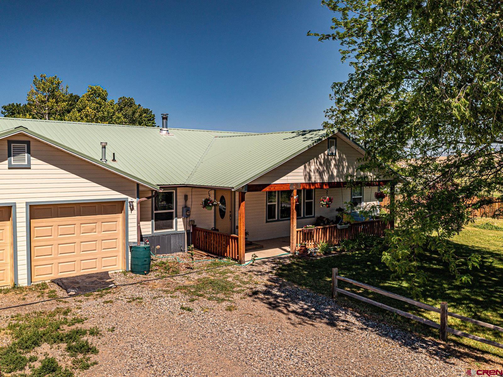 5085 3675th Road Crawford, CO 81415 - Photo 7 of 35 a view of a house with a small yard and a large tree