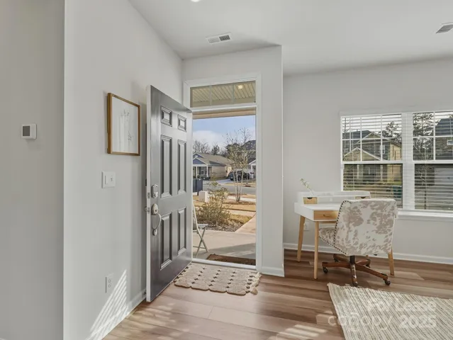 a view of a hallway with wooden floor and a livingroom