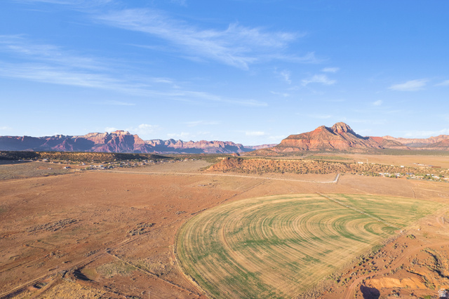 Gooseberry Way Apple Valley, UT 84737 - Photo 23 of 24 Expansive desert landscape featuring a circular irrigated field, surrounding arid terrain, and distant reddish-brown mountains under a clear sky