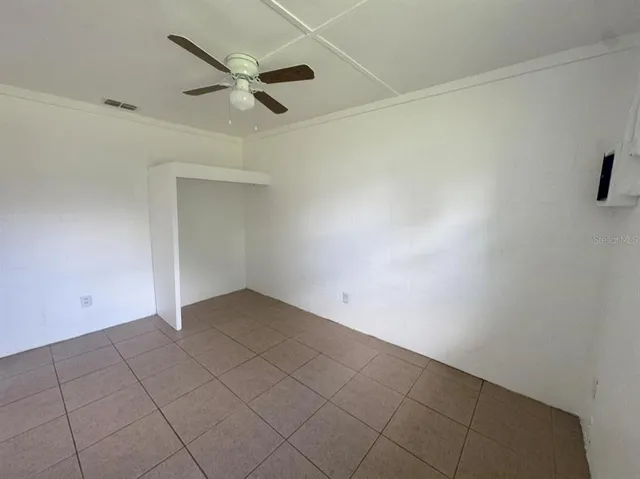 an empty room with a ceiling fan and a window
