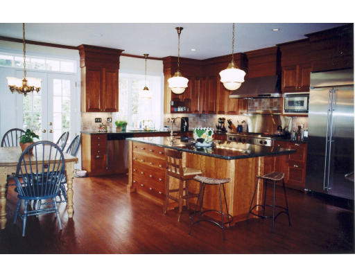 81 Forest Street Wellesley, MA 02481 - Photo 2 of 2 a kitchen with stainless steel appliances kitchen island granite countertop a table chairs and a refrigerator
