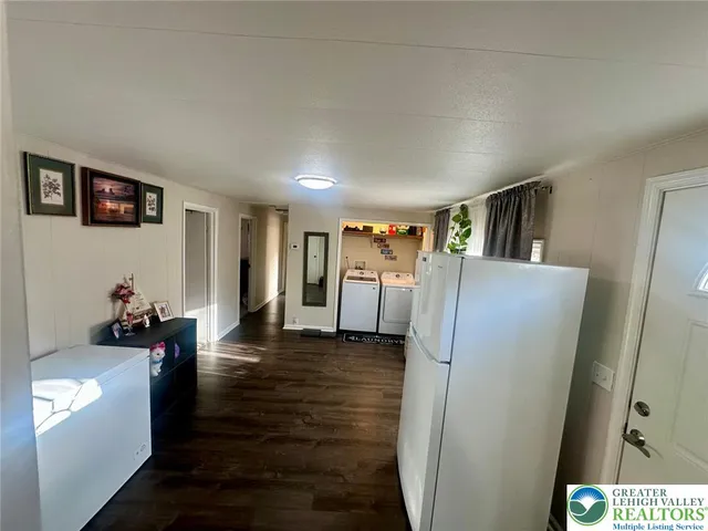 a view of hallway with furniture and a refrigerator