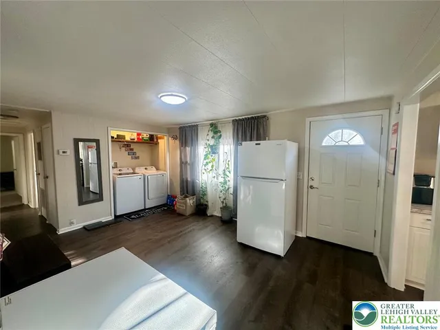 a view of a kitchen with refrigerator and wooden floor