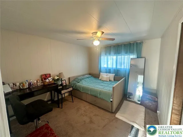 a bedroom with furniture and a chandelier fan
