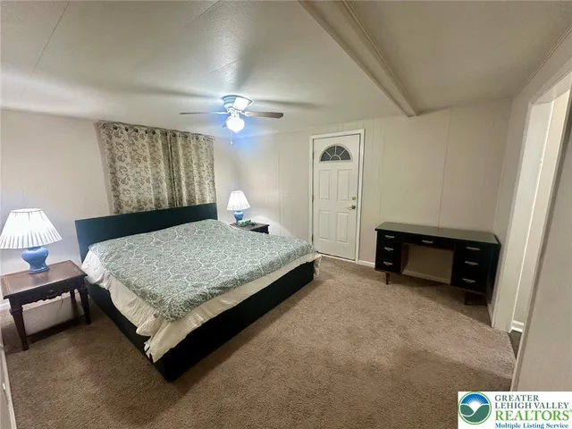 a spacious bedroom with a bed and a chandelier