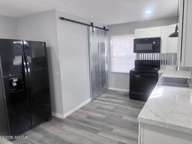 2445 Adams Avenue Macon, GA 31206 - Photo 22 of 30 a view of a refrigerator in kitchen and an empty room with wooden floor