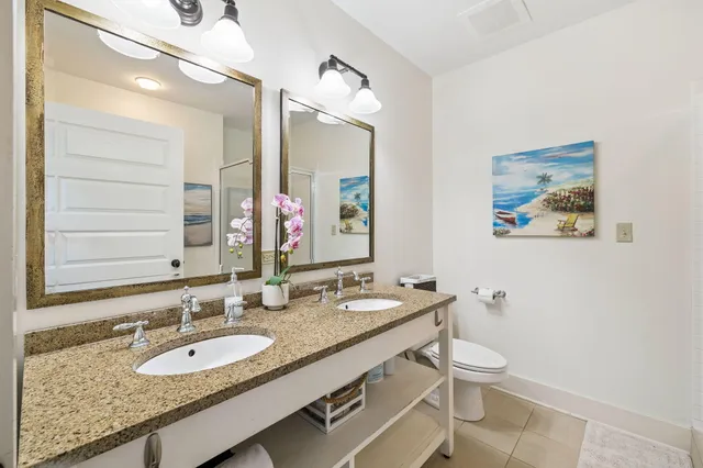 a bathroom with a granite countertop double vanity sink and a mirror