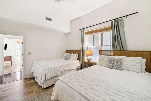 a bedroom with two beds and a large window