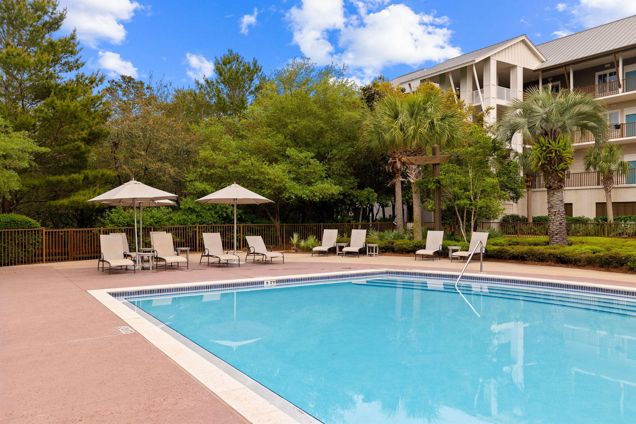 2046 West County Highway 30A, Unit M2230 Santa Rosa Beach, FL 32459 - Photo 35 of 39 a view of a swimming pool with lawn chairs under an umbrella