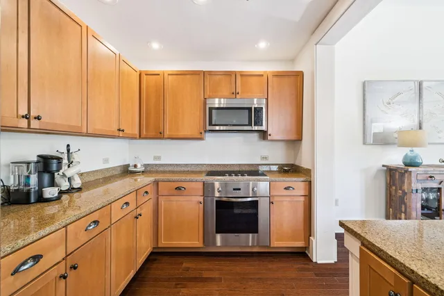 a kitchen with stainless steel appliances granite countertop a stove a sink and a microwave