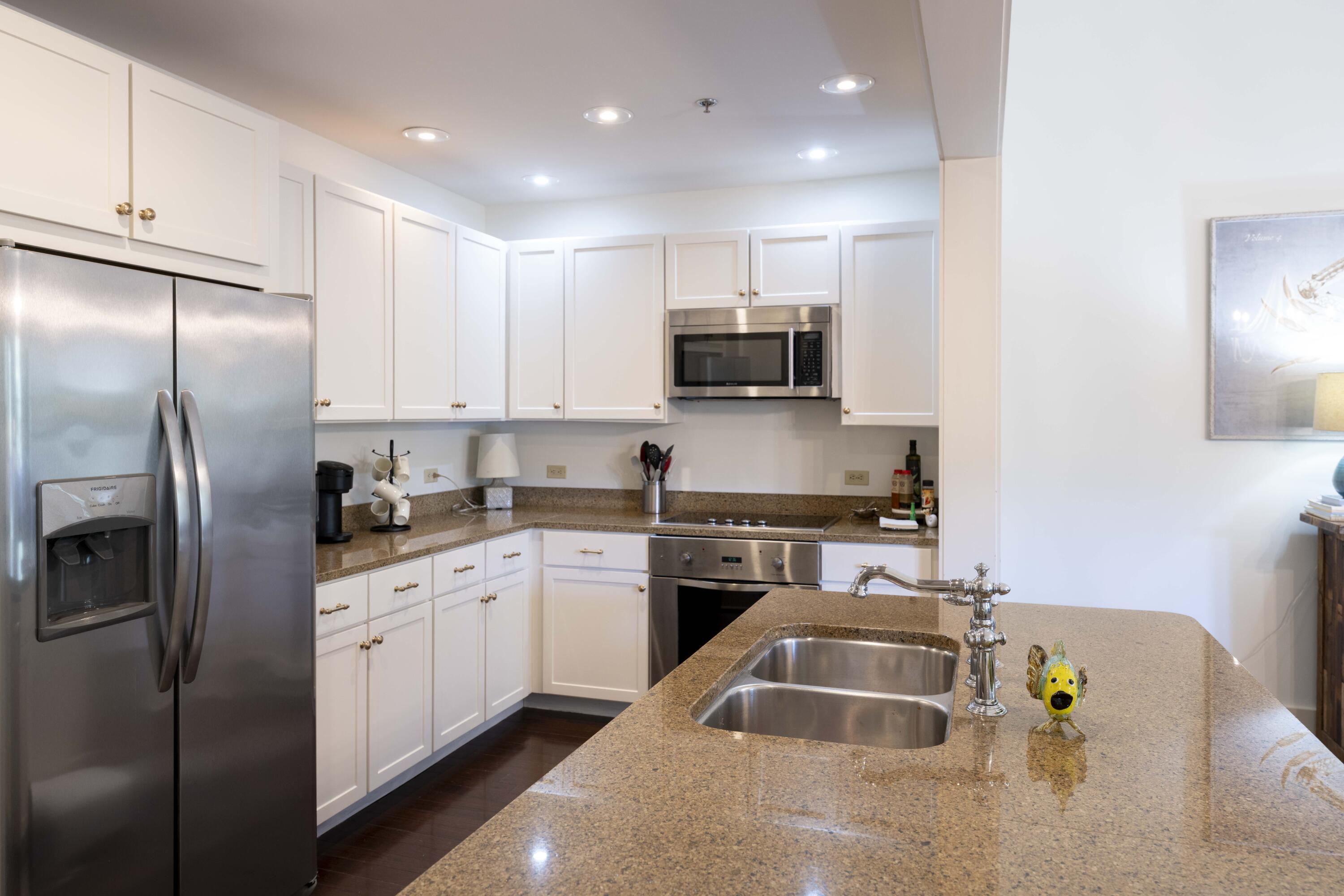 2046 West County Highway 30A, Unit M2230 Santa Rosa Beach, FL 32459 - Photo 5 of 39 a kitchen with stainless steel appliances granite countertop a sink a stove a refrigerator a microwave a counter top and cabinets