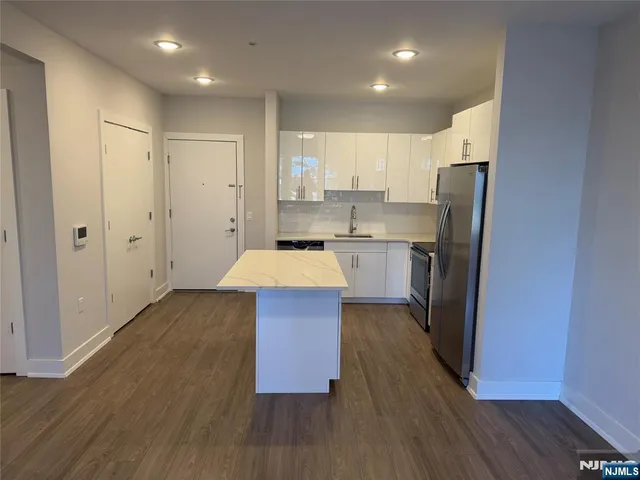 a kitchen with wooden floors and refrigerator