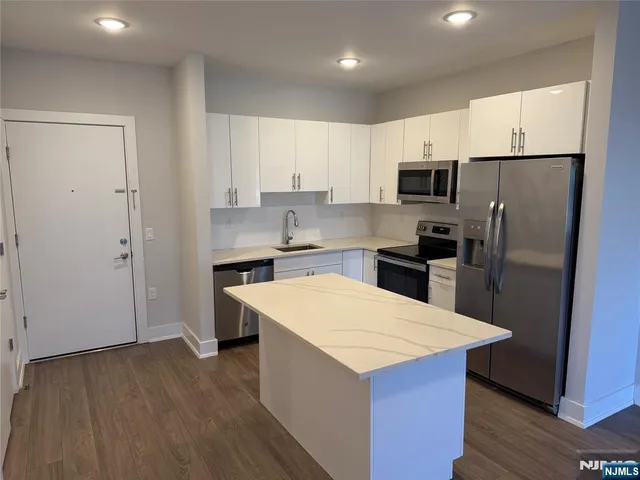 a kitchen with stainless steel appliances a refrigerator stove microwave and cabinets