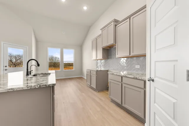 a kitchen with stainless steel appliances granite countertop a stove a sink and a refrigerator