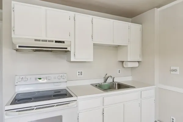 a kitchen with white cabinets and white appliances