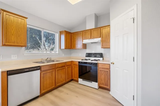 a kitchen with stainless steel appliances granite countertop a stove a sink and a microwave