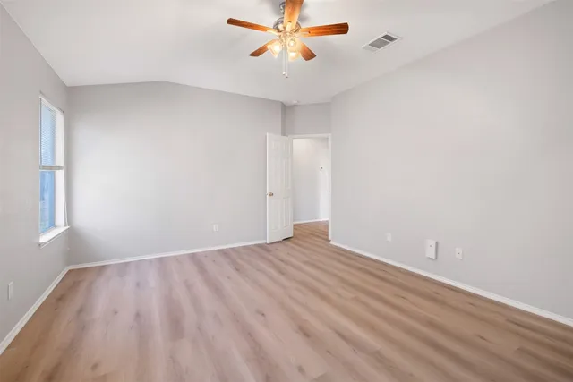 a view of a room with wooden floor and a ceiling fan