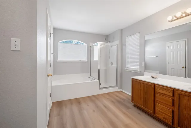 a spacious bathroom with a tub sink and mirror