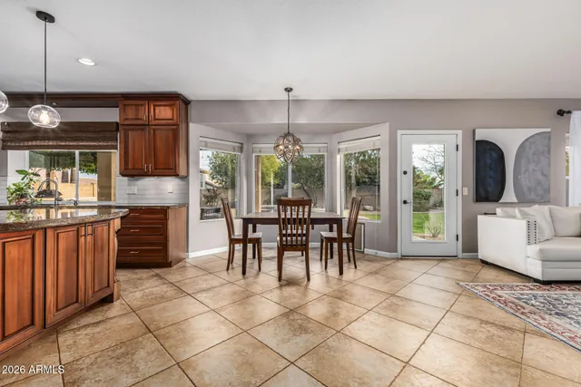 a kitchen with stainless steel appliances granite countertop a stove top oven a sink dishwasher and a refrigerator with wooden floor