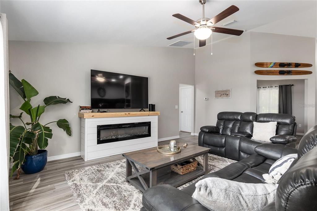 9947 Southeast 117th Street Road Belleview, FL 34420 - Photo 13 of 44 a living room with furniture a fireplace and a flat screen tv