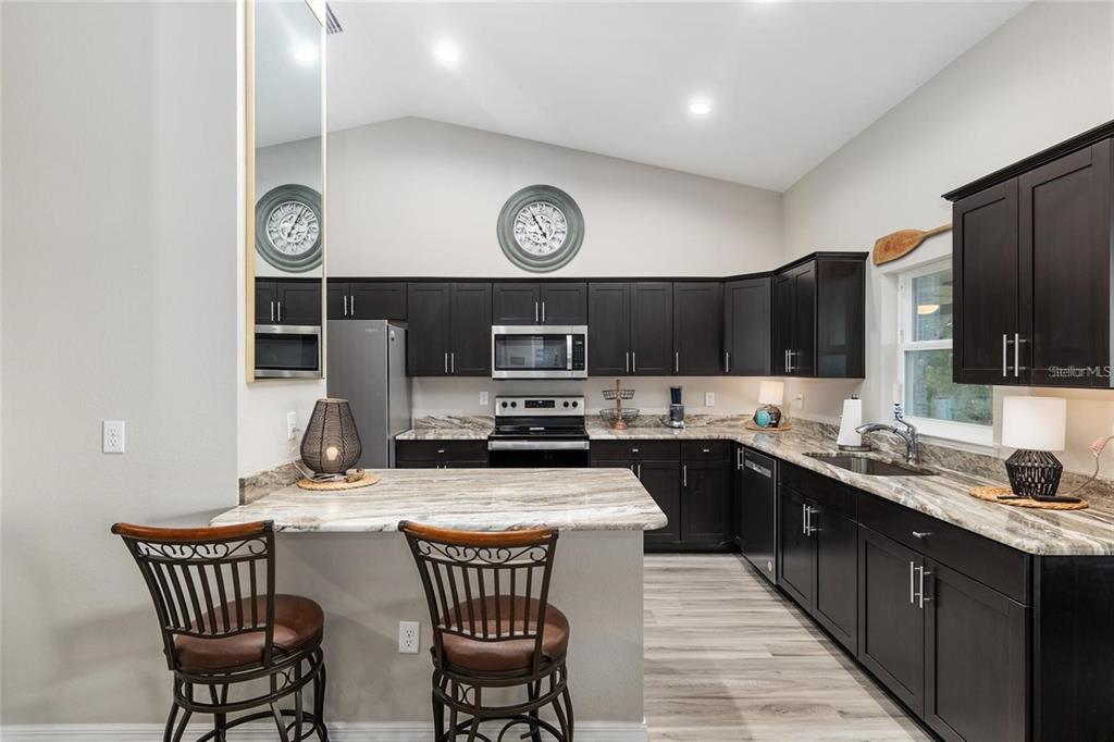 9947 Southeast 117th Street Road Belleview, FL 34420 - Photo 15 of 44 a kitchen with stainless steel appliances a sink and a refrigerator