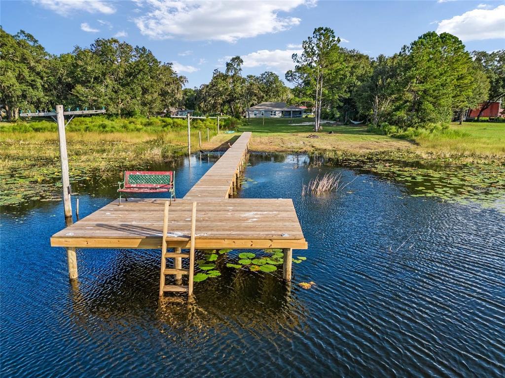 9947 Southeast 117th Street Road Belleview, FL 34420 - Photo 18 of 44 a wooden bench sitting on top of a wooden deck