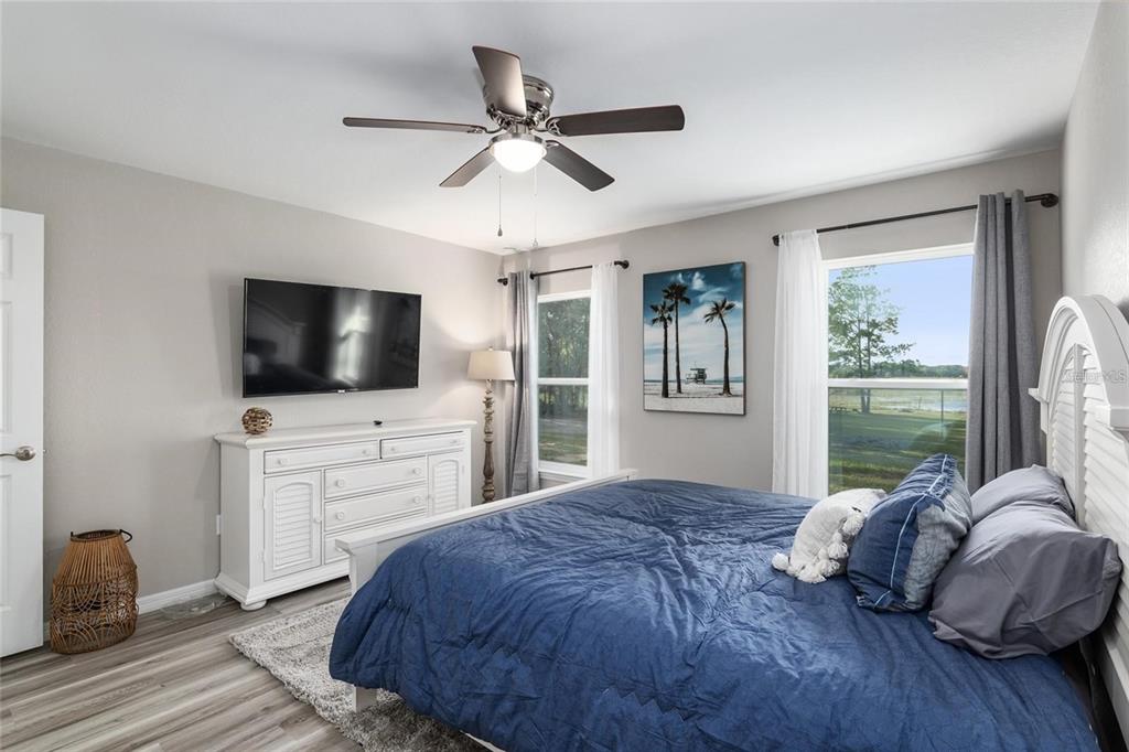 9947 Southeast 117th Street Road Belleview, FL 34420 - Photo 20 of 44 a living room with a bed furniture flat screen tv and a large window