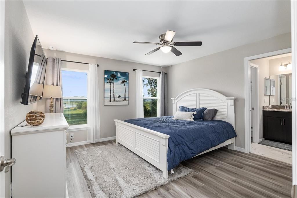 9947 Southeast 117th Street Road Belleview, FL 34420 - Photo 22 of 44 a bedroom with a bed and a chandelier