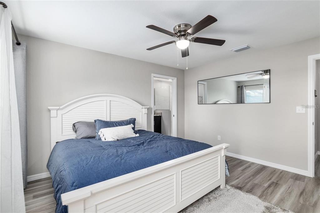 9947 Southeast 117th Street Road Belleview, FL 34420 - Photo 23 of 44 a bedroom with a large bed and a chandelier