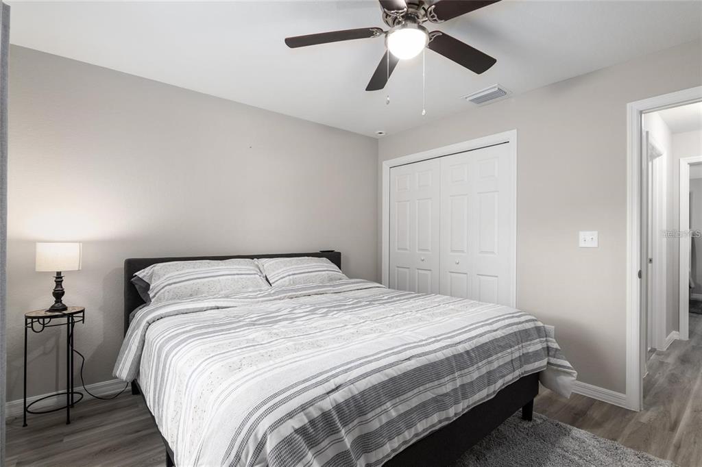 9947 Southeast 117th Street Road Belleview, FL 34420 - Photo 30 of 44 a bedroom with a bed and a chandelier