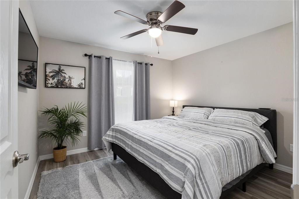 9947 Southeast 117th Street Road Belleview, FL 34420 - Photo 31 of 44 a bedroom with a large bed and a chandelier