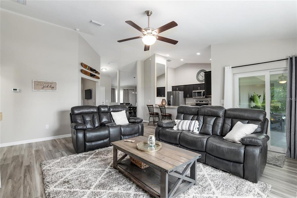 9947 Southeast 117th Street Road Belleview, FL 34420 - Photo 5 of 44 a living room with furniture ceiling fan and a rug
