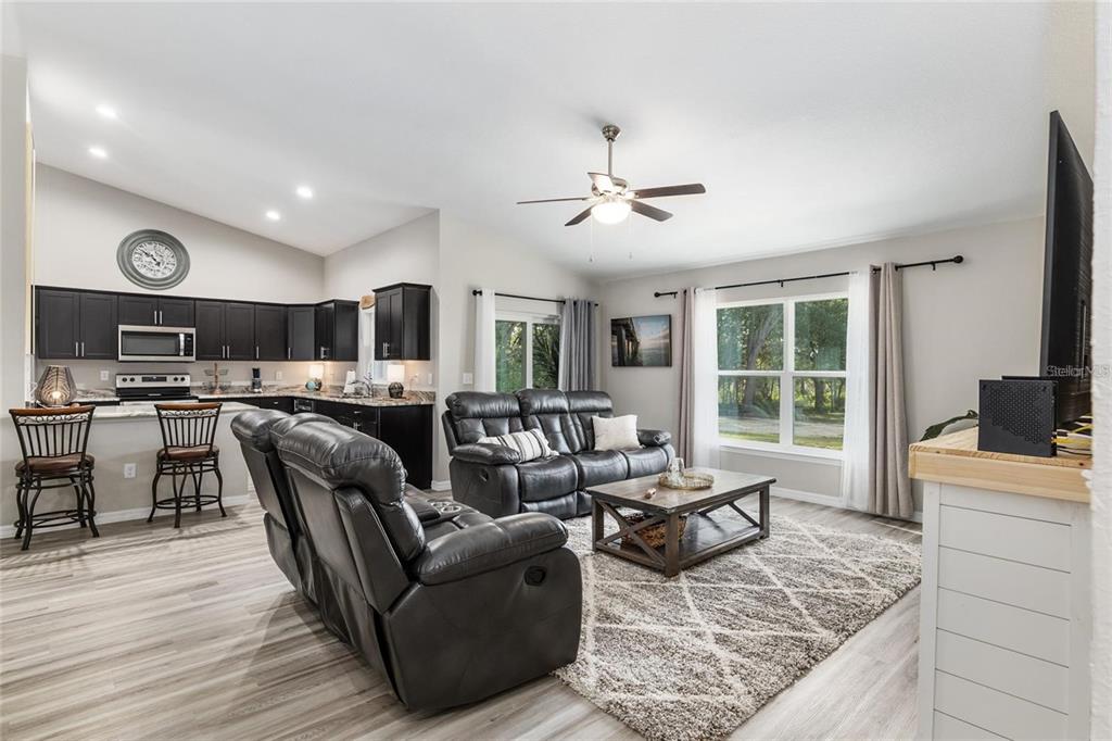 9947 Southeast 117th Street Road Belleview, FL 34420 - Photo 6 of 44 a living room with furniture kitchen view and a large window