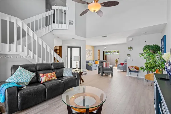 a living room with furniture flowerpot and wooden floor