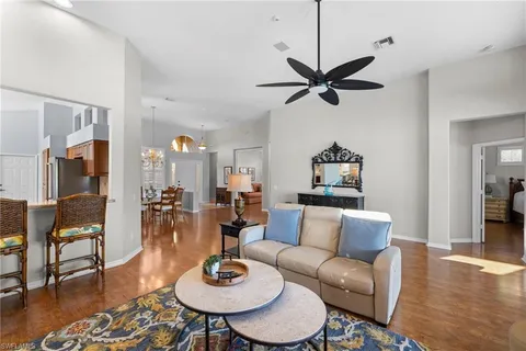 a living room with furniture a dining table and a chandelier