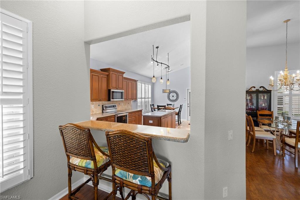 1845 Pondside Lane Naples, FL 34109 - Photo 17 of 47 a view of a dining room with furniture and wooden floor