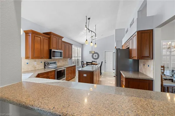a kitchen with stainless steel appliances granite countertop a sink a stove top oven a counter space and cabinets