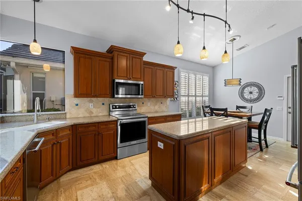 a kitchen with granite countertop a sink stove and cabinets