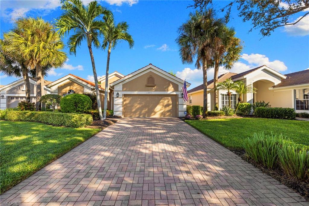 1845 Pondside Lane Naples, FL 34109 - Photo 2 of 47 a front view of a house with a yard and potted plants