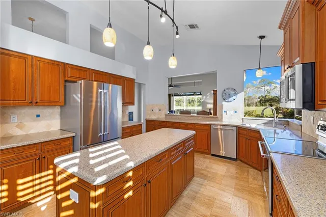 a kitchen with stainless steel appliances granite countertop a sink a stove and a refrigerator