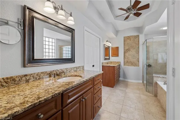 a bathroom with a granite countertop sink mirror and bathtub