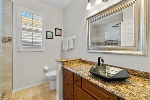 a bathroom with a granite countertop sink and a mirror