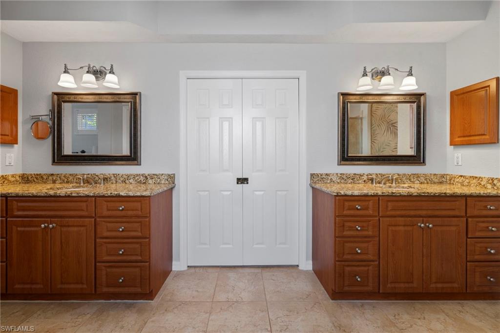 1845 Pondside Lane Naples, FL 34109 - Photo 35 of 47 a bathroom with a sink vanity and mirror
