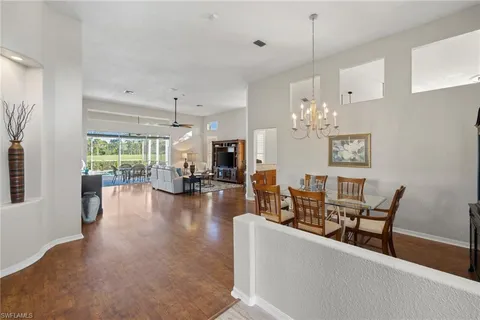 a view of a dining room and livingroom with furniture wooden floor a chandelier